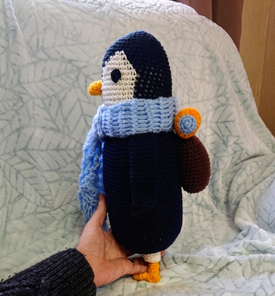 Finished crochet penguin: tangible joy of mindful autistic crafting.