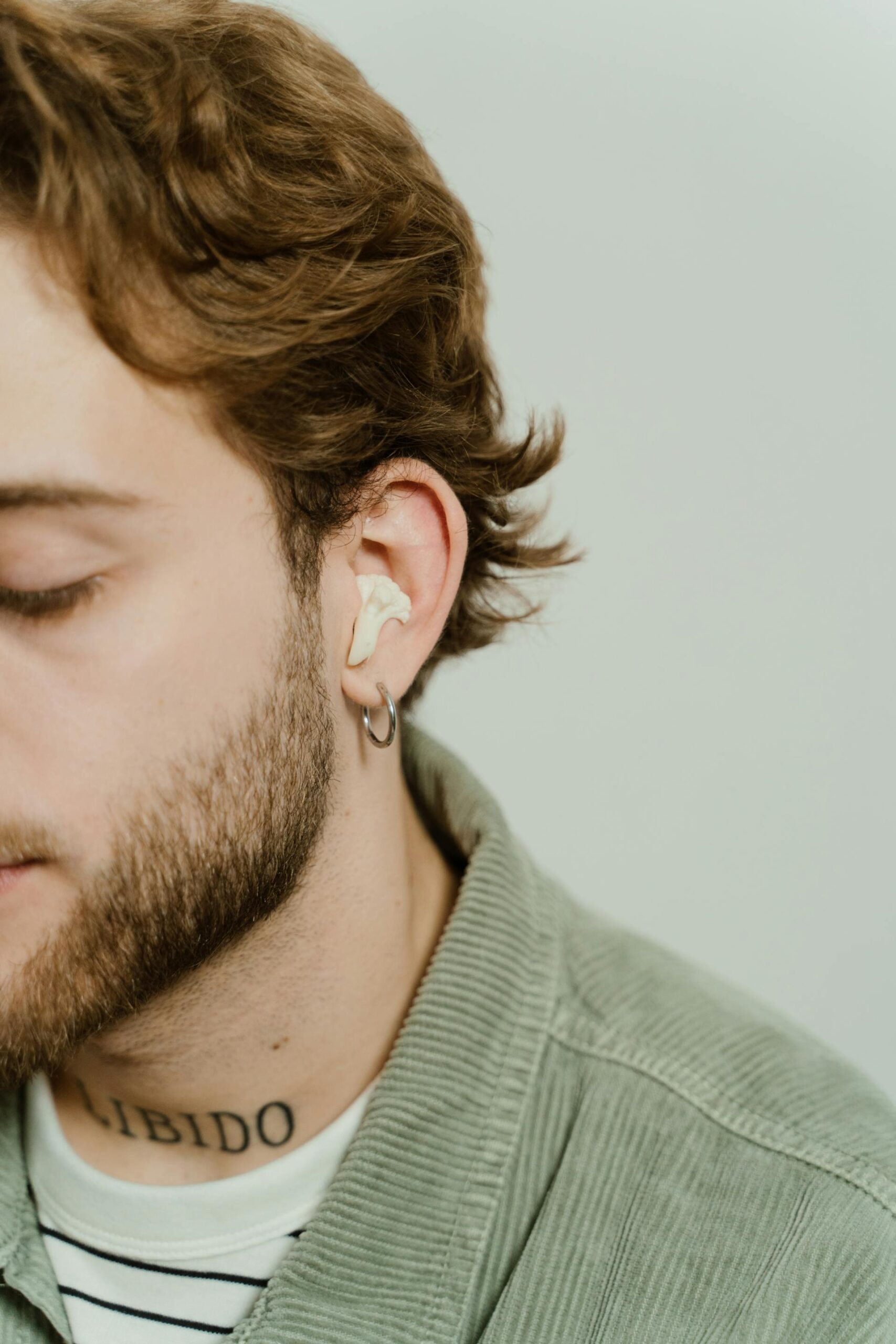 A person listening to music on an earbud, finding a deep emotional connection that resonates with their autistic identity.
