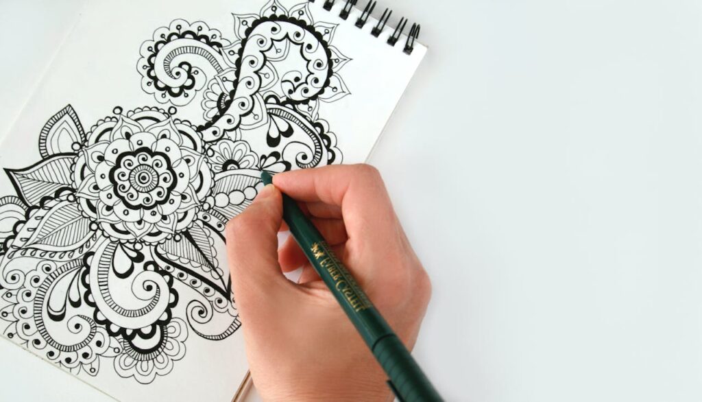 A hand engaged in drawing, showing a way to slow down energy expenditure and find a state of flow.