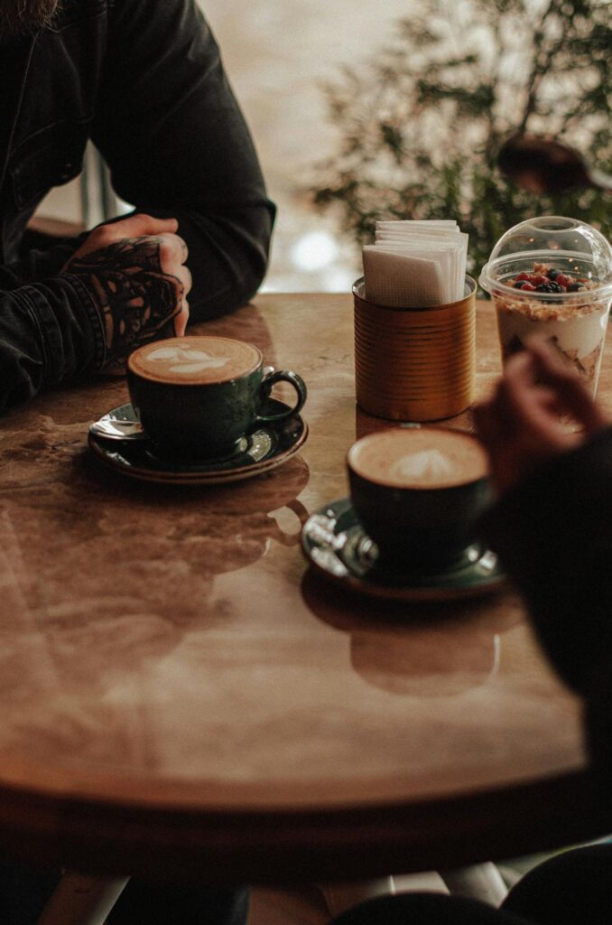 Two people sat in a coffee shop, symbolising the quiet connection and shared interests that form an autistic friendship.