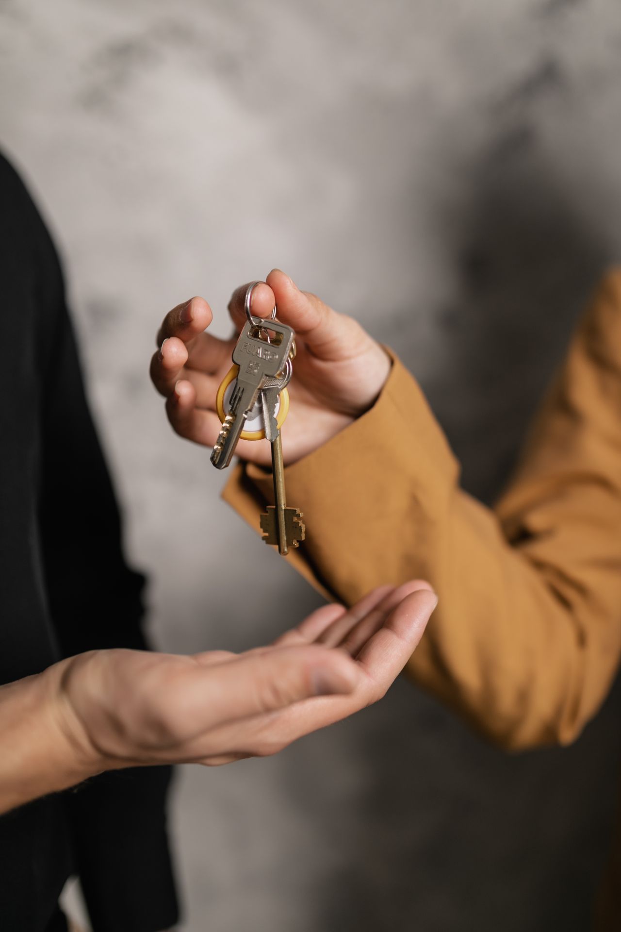 Hands returning a key — a metaphor for LGBTQ+ acceptance feeling conditional and revocable.
